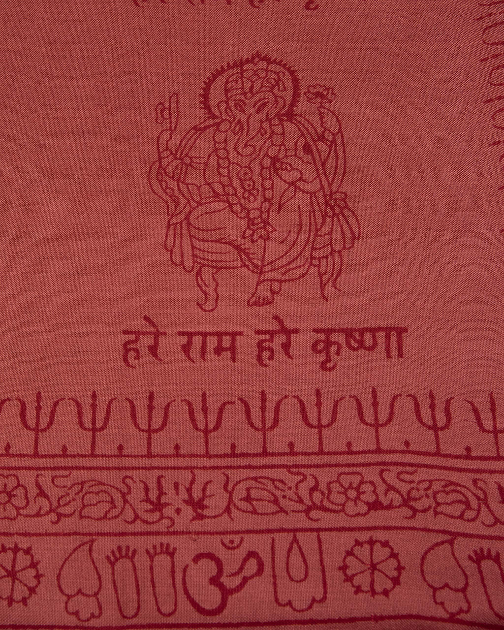Close-up of red Ganesha mantra print on Indian yoga scarf, ethically made devotional shawl from Varanasi.