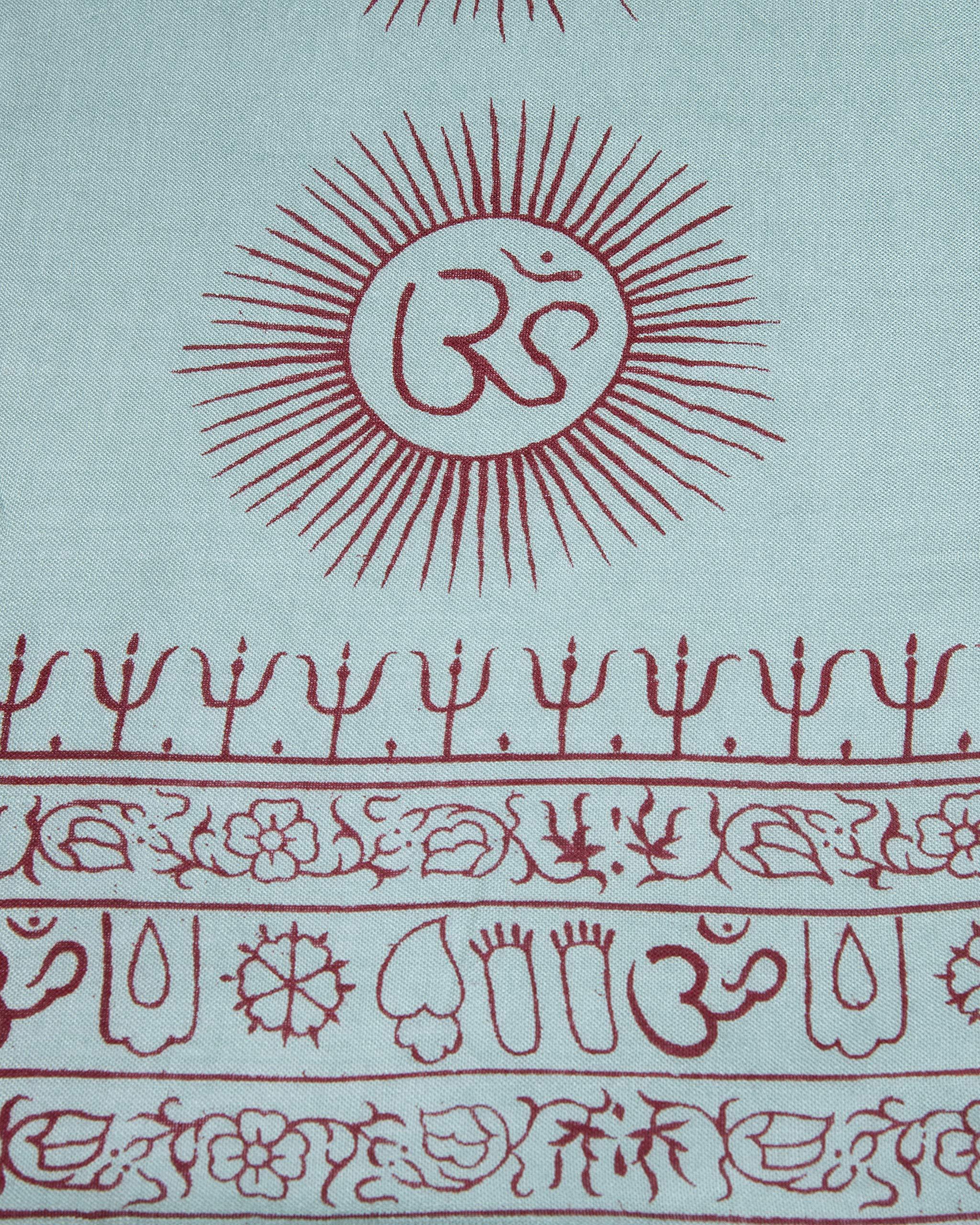 Close-up of turquoise Om symbol design on Indian yoga scarf, hand dyed and screen printed.