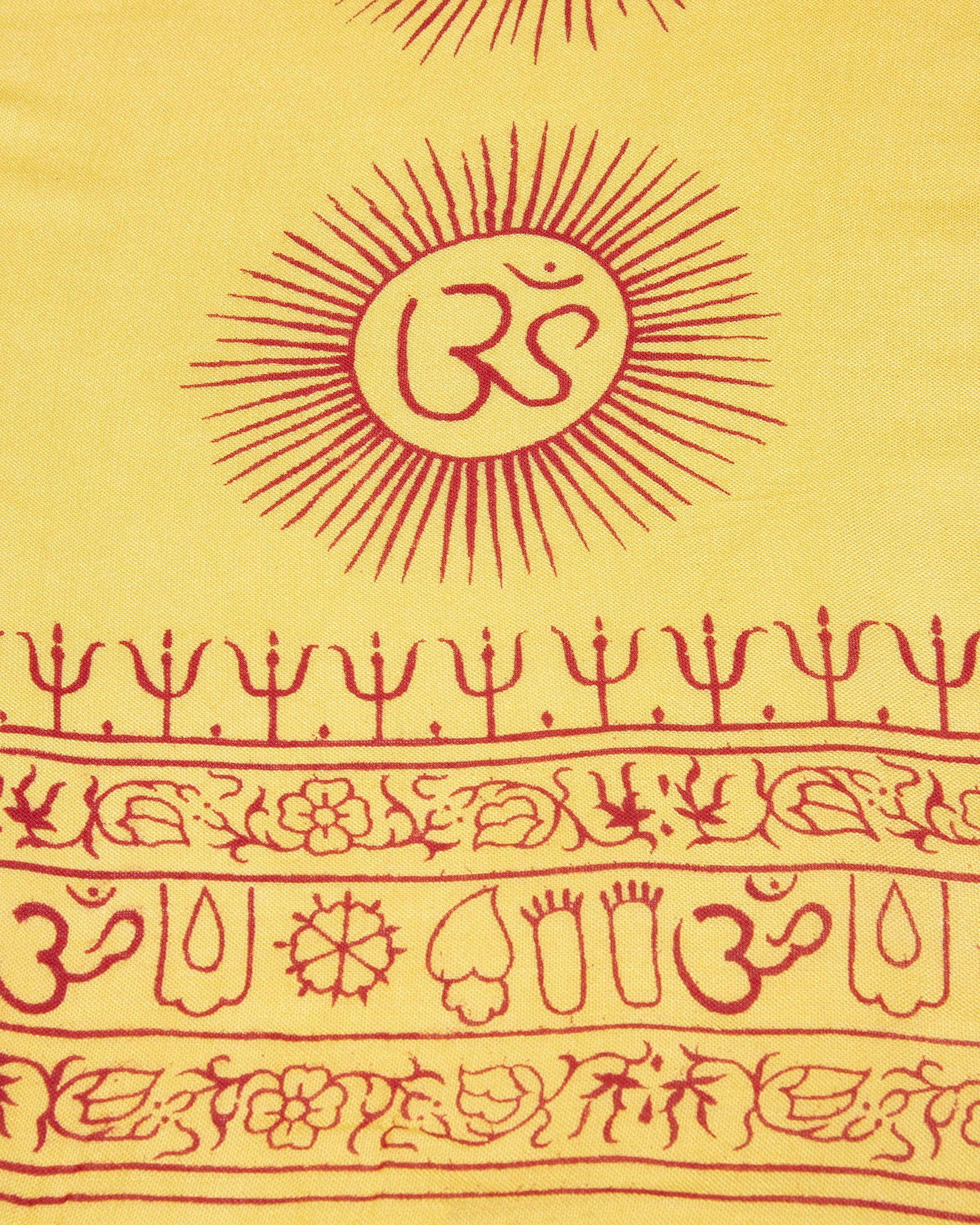 Close-up of yellow Om symbols on Indian yoga meditation scarf, traditional screen printed design.