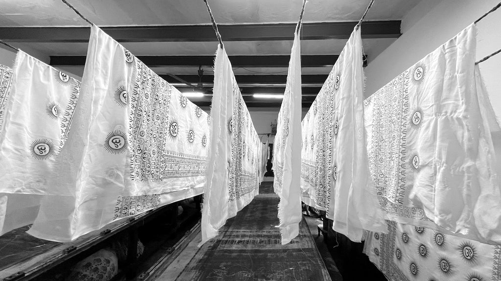 White Om patterned yoga scarves hanging to dry