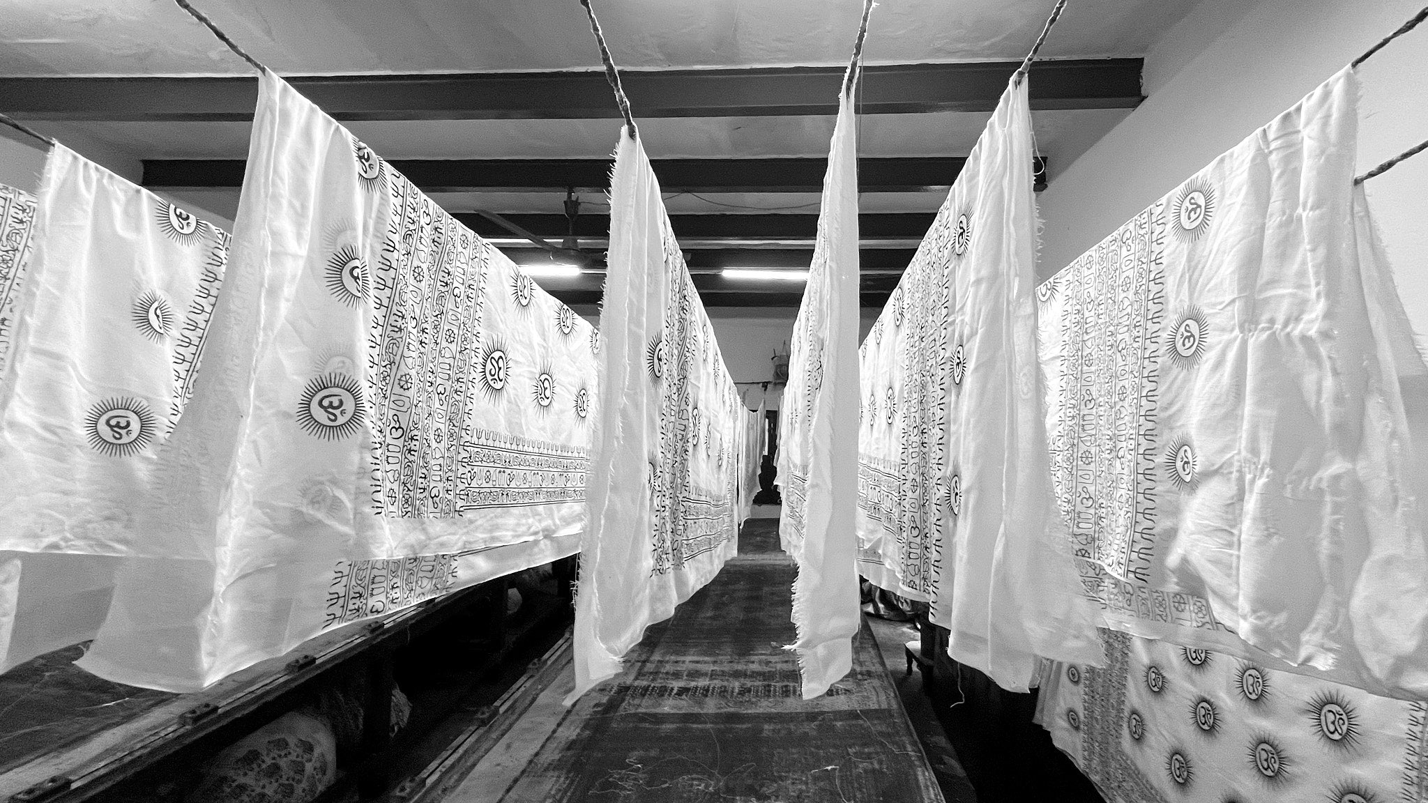 White Om patterned yoga scarves hanging to dry