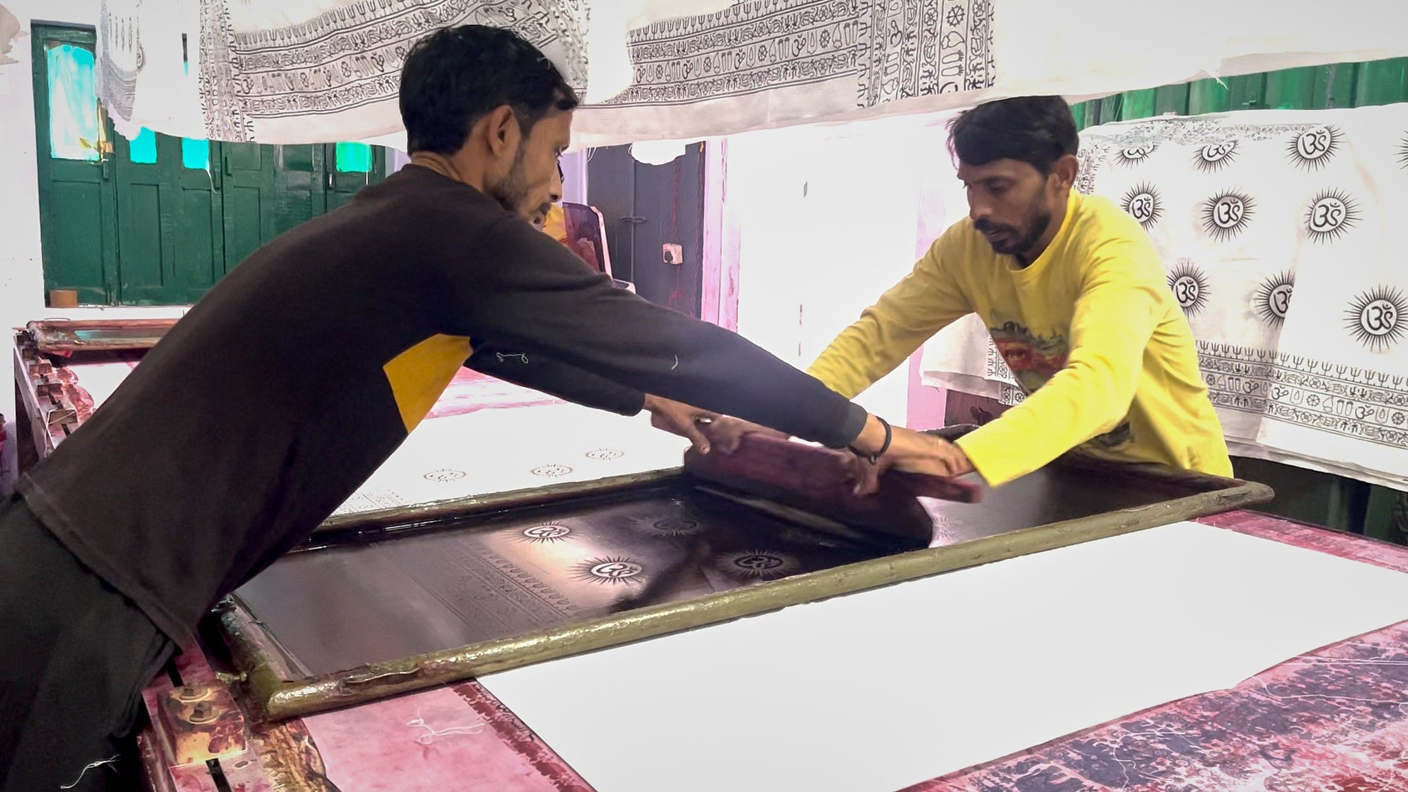 Men silk-screen printing our Om patterned yoga shawls by hand 